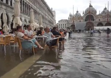 L'<b>acqua</b> alta a Venezia non scoraggia i turisti: aperitivo in piazza San Marco con i piedi a mollo